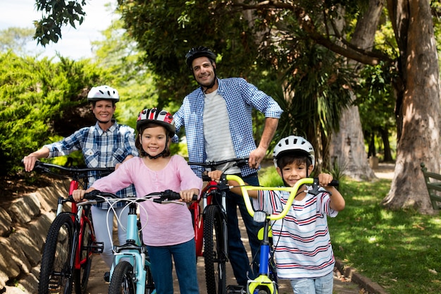 Porträt von Eltern und Kindern, die mit dem Fahrrad im Park stehen