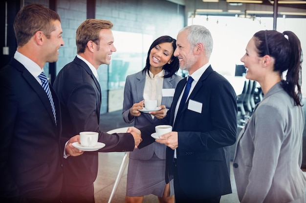 Porträt von Geschäftsleuten, die Tee trinken und während der Pausenzeit im Büro interagieren