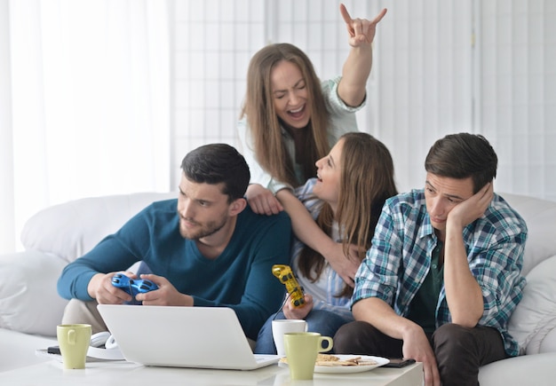 Porträt von glücklichen Freunden und Laptop zu Hause