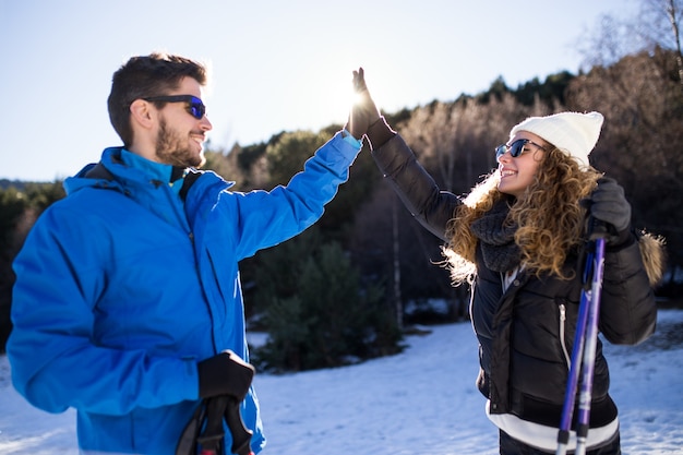 Porträt von glücklichen jungen Paaren, die Spaß über Winterhintergrund haben.