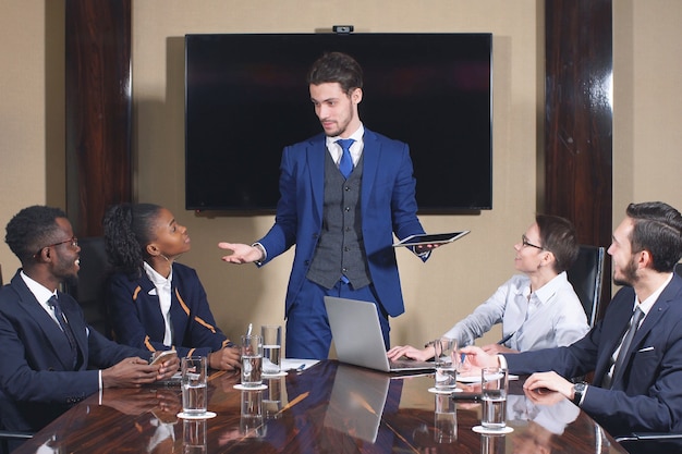 Porträt von intelligenten Geschäftspartnern, die Laptop beim Treffen verwenden.