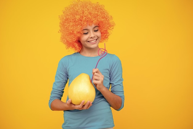 Porträt von jugendlich Kind Mädchen halten Zitrusfrüchte Pummelo oder Pampelmuse große Grapefruit isoliert auf gelbem Hintergrund Glückliches Teenager-Porträt Lächelndes Mädchen