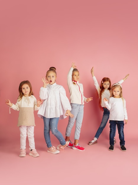 Porträt von kleinen kaukasischen Kindern mit hellen Emotionen isoliert auf rosa Studiohintergrund