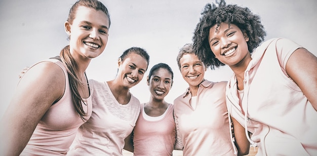 Foto porträt von lächelnden frauen, die rosa für brustkrebs im park tragen