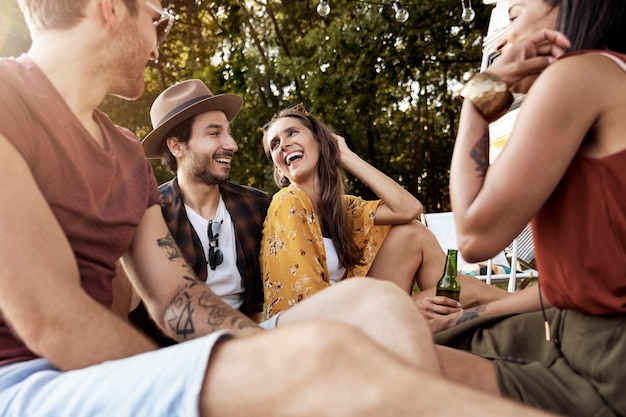 Foto porträt von lächelnden freunden, die im park sitzen