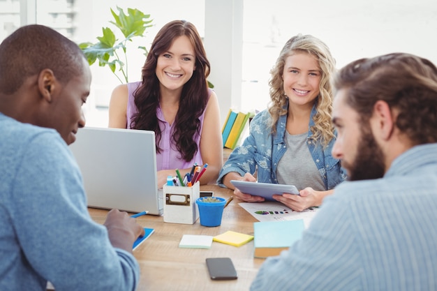 Porträt von lächelnden Geschäftsleuten mit den Männern, die am Schreibtisch arbeiten