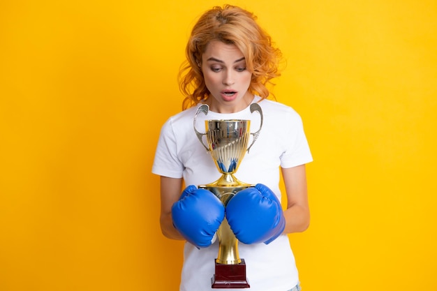 Porträt von lustig überrascht Gewinner Frau in Boxhandschuhen isoliert auf gelb Frau in Boxhandschuhen