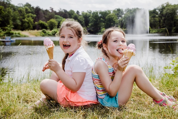 Porträt von Mädchen im Vorschulalter, die im Sommer im Park leckeres Eis essen