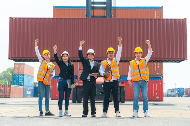 Porträt von Mann Frau Ingenieure und asiatische Fabrikarbeiter, die vor Maschinenliftcontainer und Laderaum gehen. Geschäftsleute mit selbstbewusster und intelligenter Arbeit in der Transportbranche.