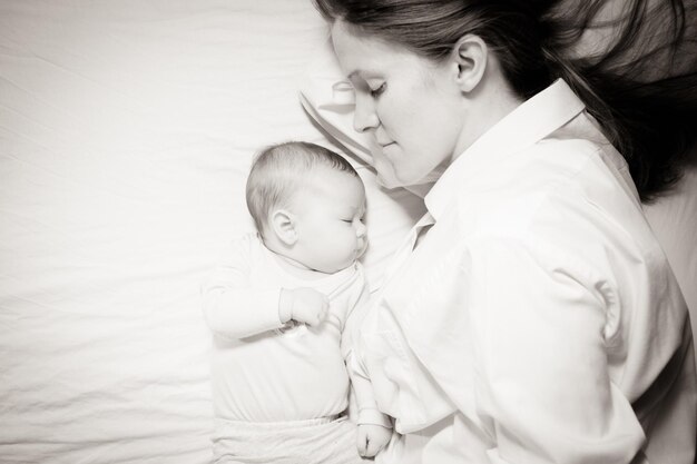 Porträt von Mutter mit Baby auf dem Bett.