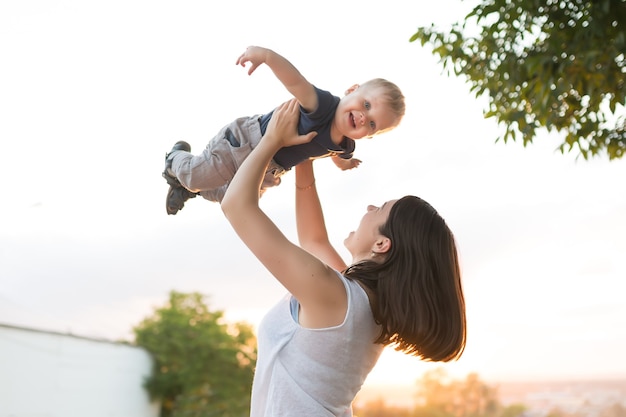 Porträt von Mutter und Baby im Freien bei Sonnenuntergang Mama und ihr einjähriger Junge haben Spaß