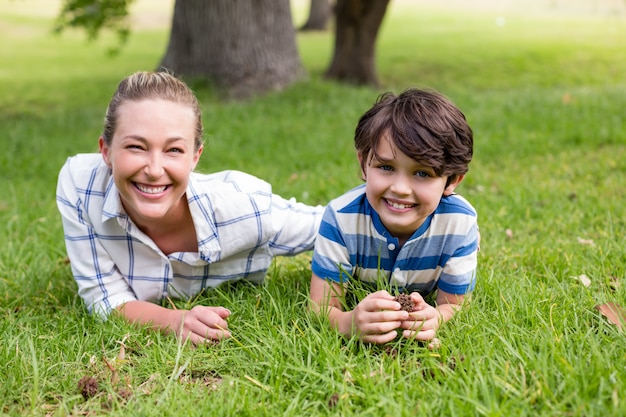 Porträt von Mutter und Sohn, die an einem sonnigen Tag im Park liegen