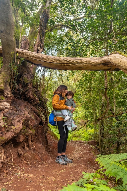 Porträt von Mutter und Sohn in einem Baum auf dem Weg im moosigen Baumwald des Garajonay-Nationalparks La Gomera Kanarische Inseln Auf dem Ausflug nach Las Creces