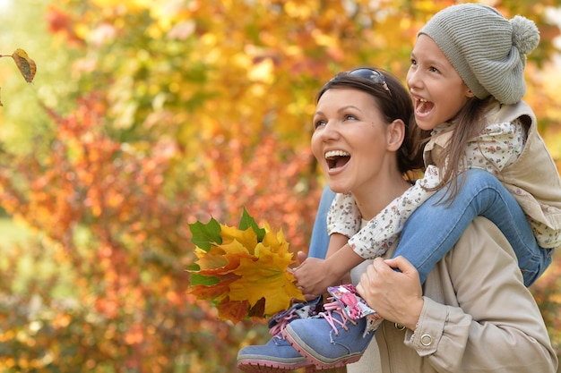 Porträt von Mutter und Tochter, die sich im Herbstpark umarmen