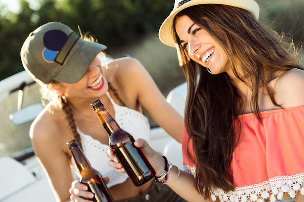 Porträt von schönen jungen Frauen, die Bier trinken und den Sommertag genießen.