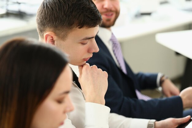 Porträt von selbstbewussten Menschen, die sich ernsthaft Geschäftspapiere während des Arbeitstreffens ansehen