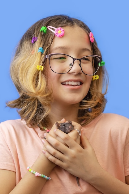 Porträt von Teenager-Mädchen mit Haustier Ratte auf blauem Hintergrund