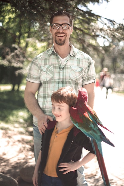 Foto porträt von vater und sohn mit ara-papageienfotos im vergnügungspark