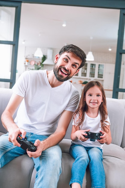 Porträt von Vater und Tochter beim Computerspiel im Wohnzimmer