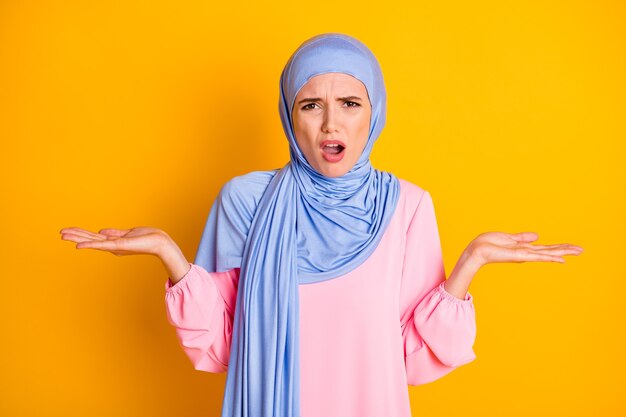 Porträt von ziemlich verzweifelten Muslimen mit Hijab gleichgültigen Missverständnissen Ausdruck einzeln auf hellgelbem Hintergrund