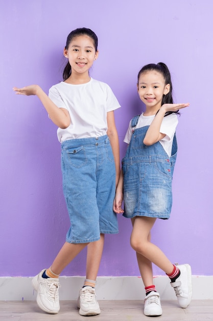 Porträt von zwei asiatischen Mädchen auf lila Hintergrund