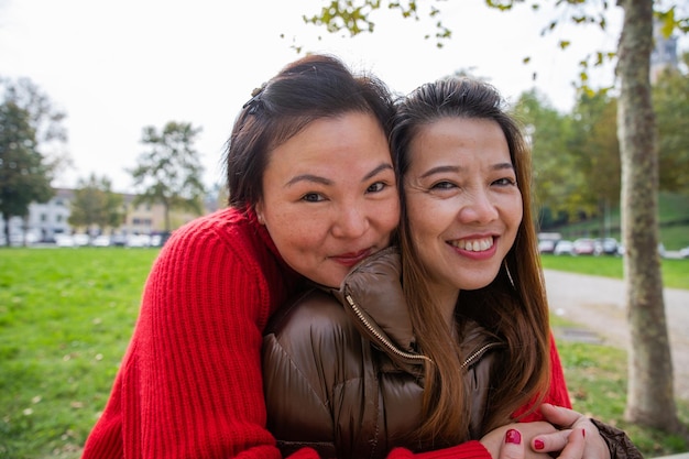 Porträt von zwei attraktiven und süßen chinesischen Frauen, die in die Kamera lächeln