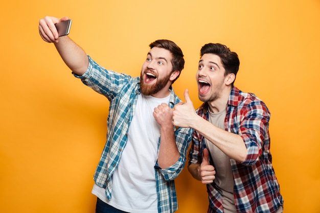 Porträt von zwei aufgeregten jungen Männern, die ein Selfie machen