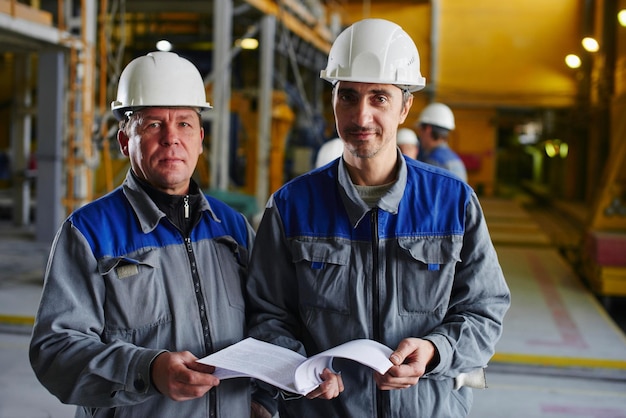 Porträt von zwei Fabrikarbeitern mit Dokumenten in der Hand das Gebäude des Unternehmens