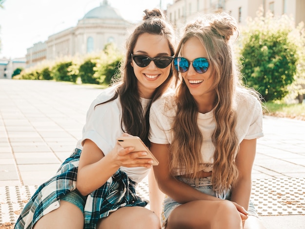 Porträt von zwei jungen schönen lächelnden Hippie-Frauen in trendiger weißer Sommer-T-Shirt-Kleidung