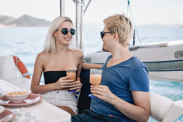 Porträt von zwei jungen verliebten Freund und Freundin, die in einem lokalen Café auf einer Yacht trinken.