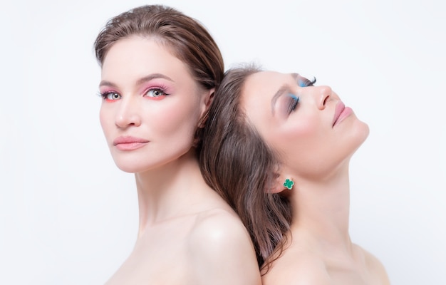 Porträt von zwei schönen Mädchen mit trotzigem Make-up auf weißem Hintergrund. Konzept der weiblichen Freundschaft. Hohe Qualität