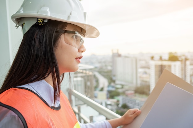 Foto porträtasien-fraueningenieur, der an der baustelle arbeitet