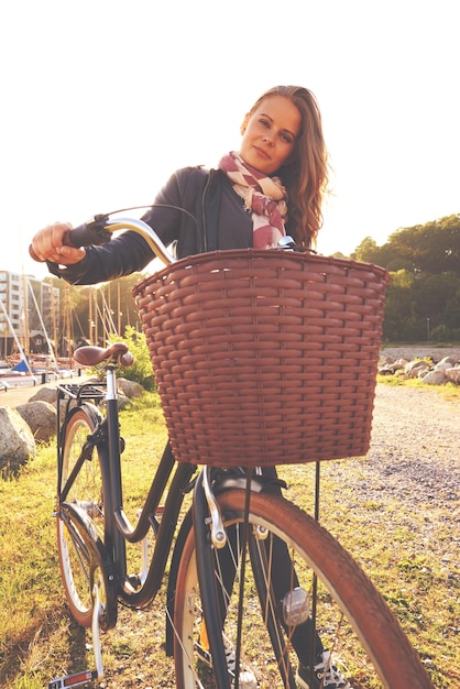 Foto porträtflare und ein mädchen mit ihrem fahrrad im park für reisefreiheit oder umweltfreundliches abenteuer sommer radfahren und eine junge person im freien auf dem land für eine radfahrt mit einem korb