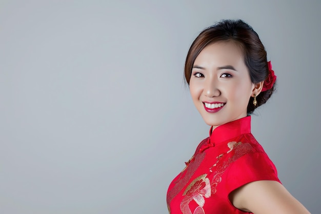 Porträtfotografie: lächelnde asiatische chinesische Frau im traditionellen Cheongsam Qipao-Kleid auf weißem oder grauem Hintergrund chinesisches Neujahrsfestkonzept