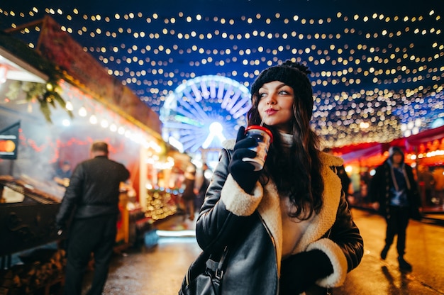 Porträtfrau an der Weihnachtsfee, die heiße Schokolade trinkt