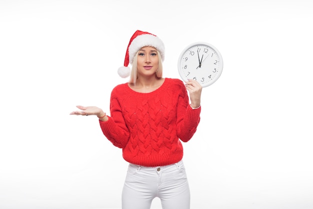 Porträtfrau, die Weihnachtsmütze hält Uhr hält