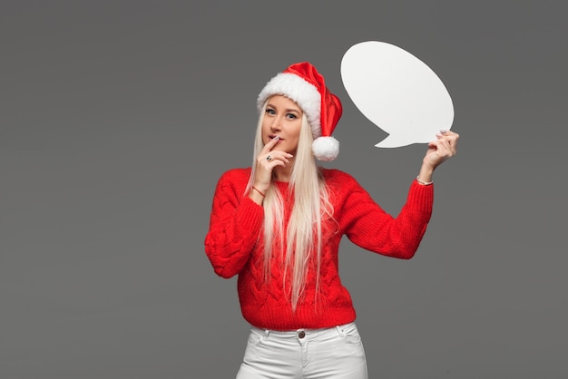 Foto porträtfrau mit weihnachtsmütze, die eine sprechblase hält
