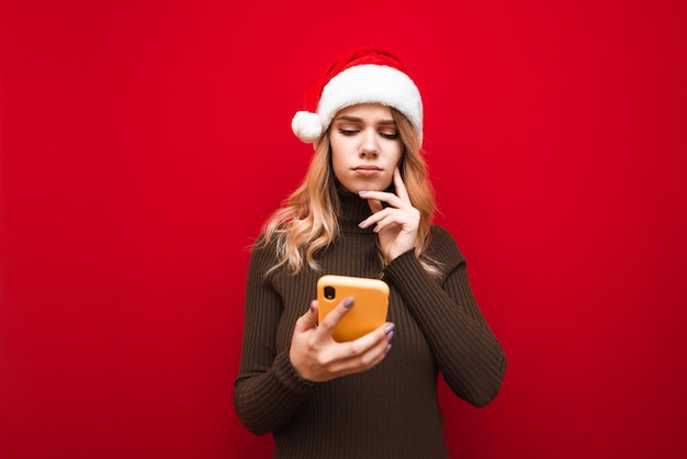 Porträtfrau mit Weihnachtsmütze mit Telefon