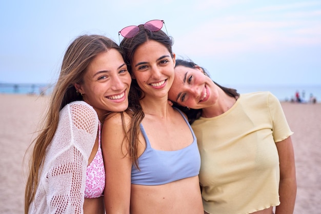 Foto porträtgruppe kaukasischer frauen, die auf dem strand kamera suchen, sie sind glücklich im sommerurlaub