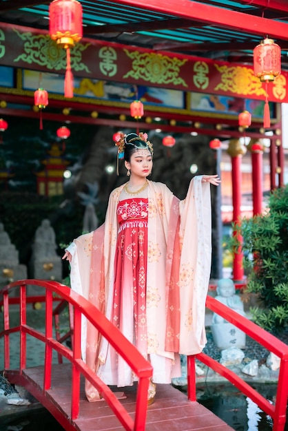 Porträtlächeln Nettes kleines asiatisches Mädchen, das chinesische Kostüme trägt, Dekoration für das chinesische Neujahrsfest, feiert die Kultur Chinas am chinesischen Schrein Öffentliche Orte in Thailand