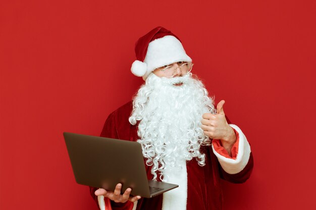 Porträtmann verkleidet als Weihnachtsmann mit Laptop