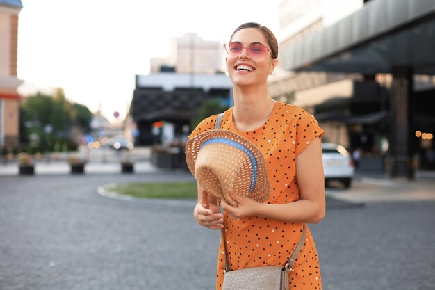 Porträtmodefrau posiert in der Stadt, Sommerstraßenmode. Lachendes und lächelndes Porträt.