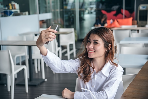 Porträts von Pretty Beautiful Asiatin, die ein Foto durch selfie in städtischem macht.