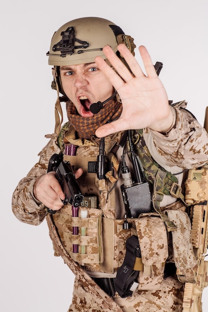 Porträtsoldat oder privater Militärunternehmer, der Stoppschild mit schwarzer Pistolenkriegsarmee-Waffentechnologie und Menschenkonzept macht Bild auf weißem Hintergrund