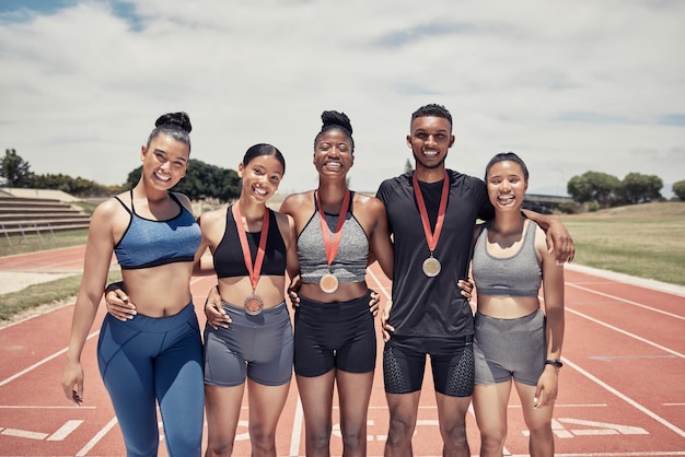 Foto porträtvielfalt und team für sportsieger für wettbewerb und gruppenlächeln zusammen outdoor teamwork fitnesstraining und medaillen für spiele erfolg und sieg für umarmung glücklich und auf der strecke