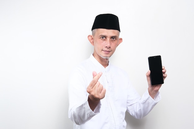 Portrait asiatischer muslimischer Mann mit Handy mit koreanischem Symbol Handherz, eine Botschaft der Liebeshand