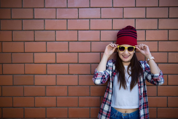 Portrait asiatisches Hipster-Mädchen auf Backsteinmauerhintergrund Lebensstil der thailändischen Bevölkerung