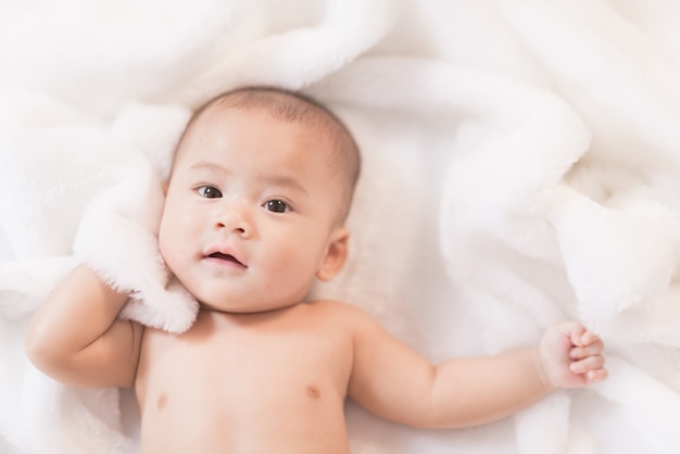 Portrait-Asien-Baby auf weißem Bett