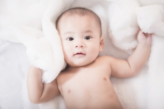 Portrait-Asien-Baby auf weißem Bett