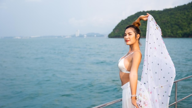 Portrait Attraktiv Fröhliche, schöne, sexy asiatische Frau, die Badebekleidung trägt, die auf dem Bootsdeck genießt, das eine Luxusyacht segelt Urlaubsreise Sommerurlaub